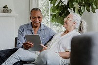 Elderly couple using a tablet on a couch