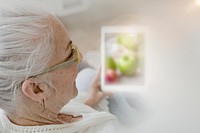 Elderly woman using a tablet on a couch