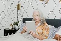 Elderly woman using a tablet in bed