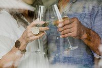 Elderly couple clinking their white wine glass