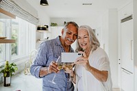 Elderly couple taking a selfie while having a wine
