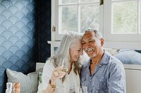 Elderly couple having a white wine