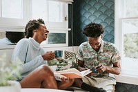 Happy black couple reading a book at home