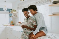 Cute black couple taking notes in the kitchen