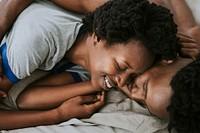 Cute happy black couple playing in bed