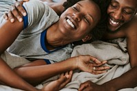 Cute happy black couple playing in bed