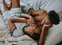 Cute happy black couple playing in bed