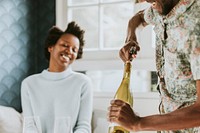 Happy black man uncorking a wine bottle