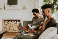 Black people in the living room using a laptop