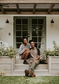Cheerful black couple sitting on theri front porch