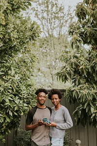 Black couple with coffee in the garden