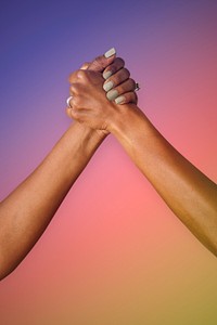 Gay couple holding hands on a colorful rainbow gradient background