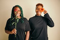 Happy lesbian couple standing with flowers