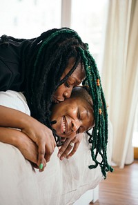 Happy lesbian couple smooching in bed