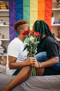 Happy lesbian couple with roses and a colorful flag