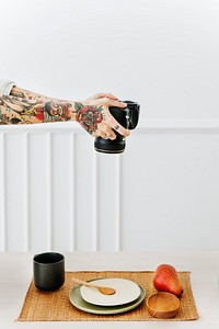 Tattooed photographer shooting an aerial image of a plate decor