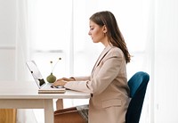 Businesswoman typing on her laptop on a wooden table