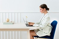 Businesswoman typing on her laptop on a wooden table