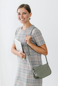 Woman in a gray plaid dress holding a tablet