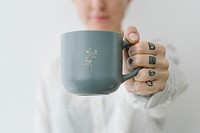 Smiling tattooed woman having a cup coffee mockup