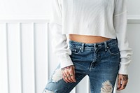 Tattooed woman in a white top crop and a ripped jeans