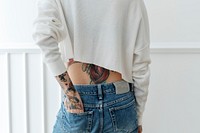 Tattooed woman tucked her hand in a jeans back pocket