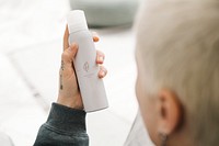 Blond hair woman holding a white spray bottle mockup