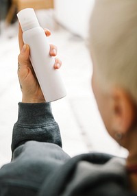 Blond hair woman holding a white spray bottle