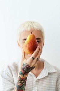 Tattooed woman showing a red blush pear