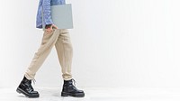 Tattooed woman walking with a gray book