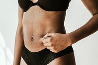 Woman in underwear pinching her tummy