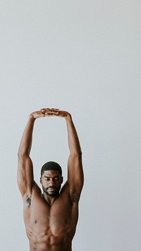 Barechested black man stretching his arms