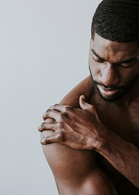 Bared chest black man touching his shoulder