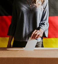 German woman casting her vote to a ballot box