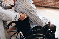 Wife pushing her husband's wheelchair