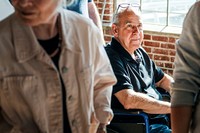 Elderly man on a wheelchair in a meeting