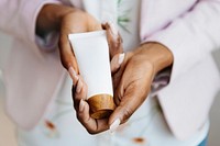 Woman holding lotion with both hands