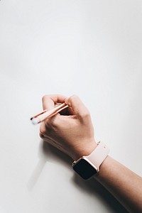 woman wearing a smartwatch writing on a paper