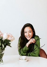 Beautiful cheerful woman standing by a white wall