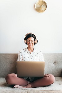 Happy woman with headphones on the couch