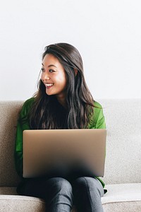 Cheerful woman using a laptop at home