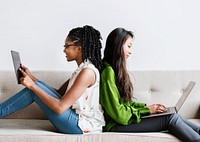 Diverse women sitting together using digital devices