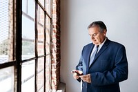 Businessman using his mobile phone by the window