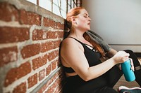 Exhausted woman against a brick wall