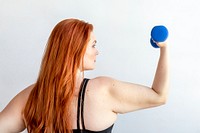 Rear view of active woman with dumbbell