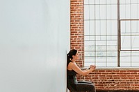 Sporty woman doing squats against a wall