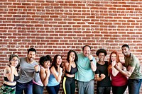 Group of sportive people by a brick wall