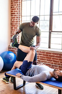 Trainer helping his student stretch