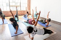 Trainer and her students in yoga pose