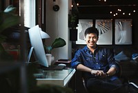 Happy freelancer sitting at his computer desk at home